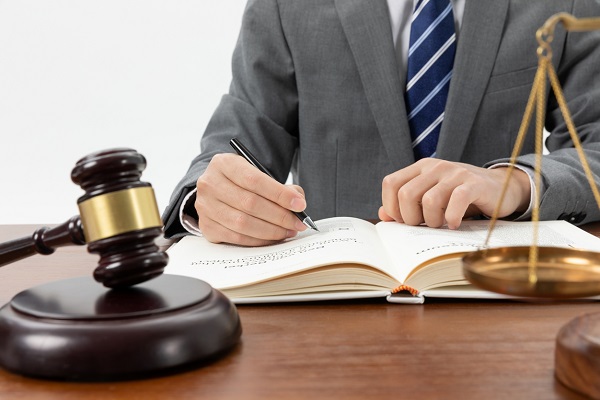 closeup-shot-person-writing-book-with-gavel-table.jpg